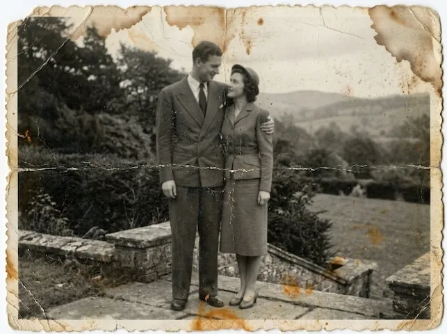 The same landscape photo before restoration: faded, scratched, and dim.