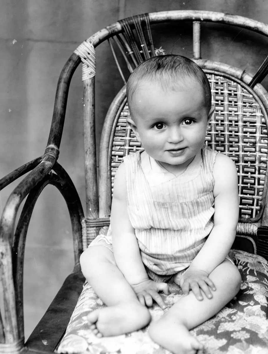 The restored photo: the child, wicker chair, and cushion clean and sharp.